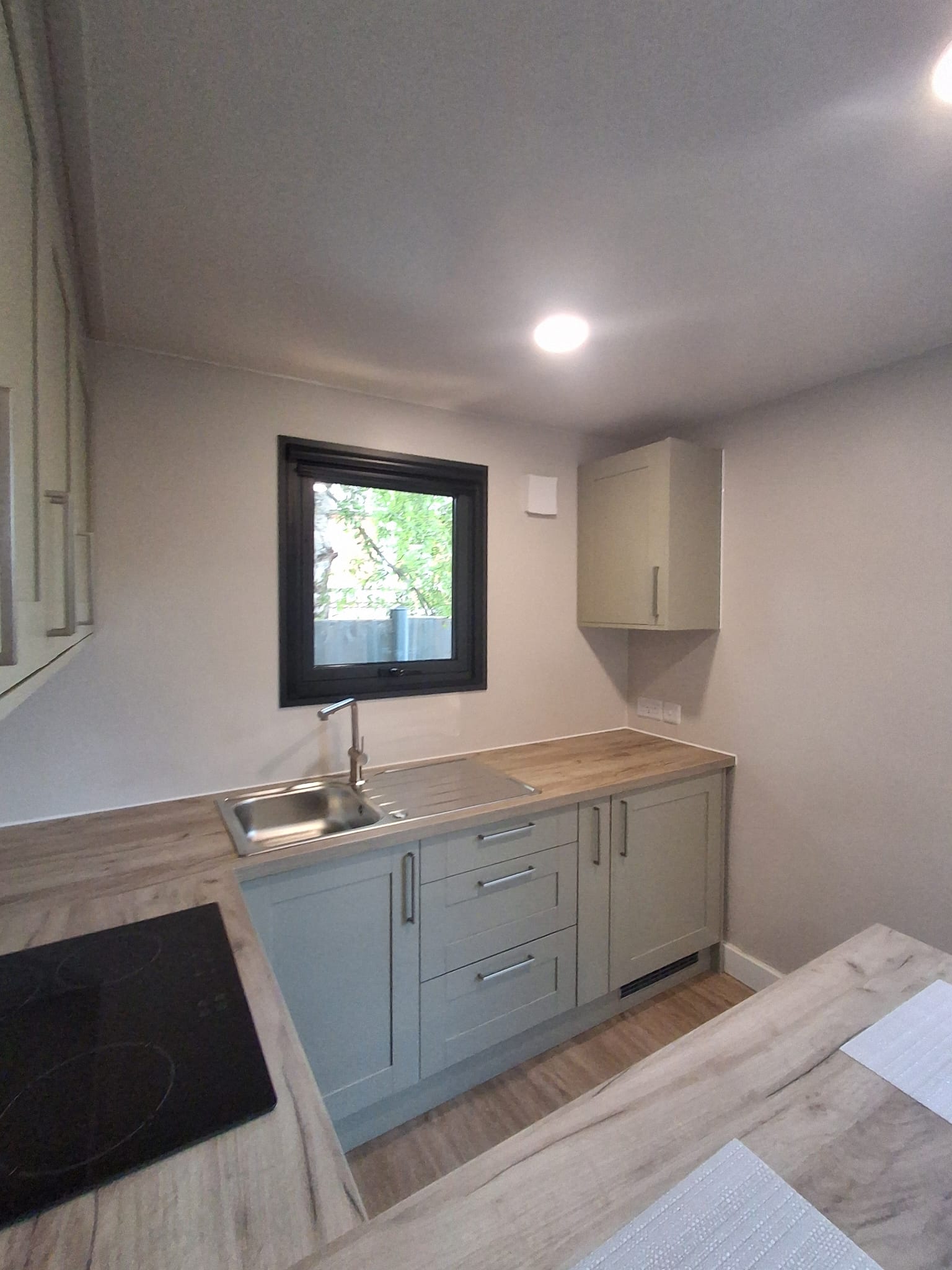 Finished PrefabX modular home kitchen with shaker units, wood worktop and an induction hob