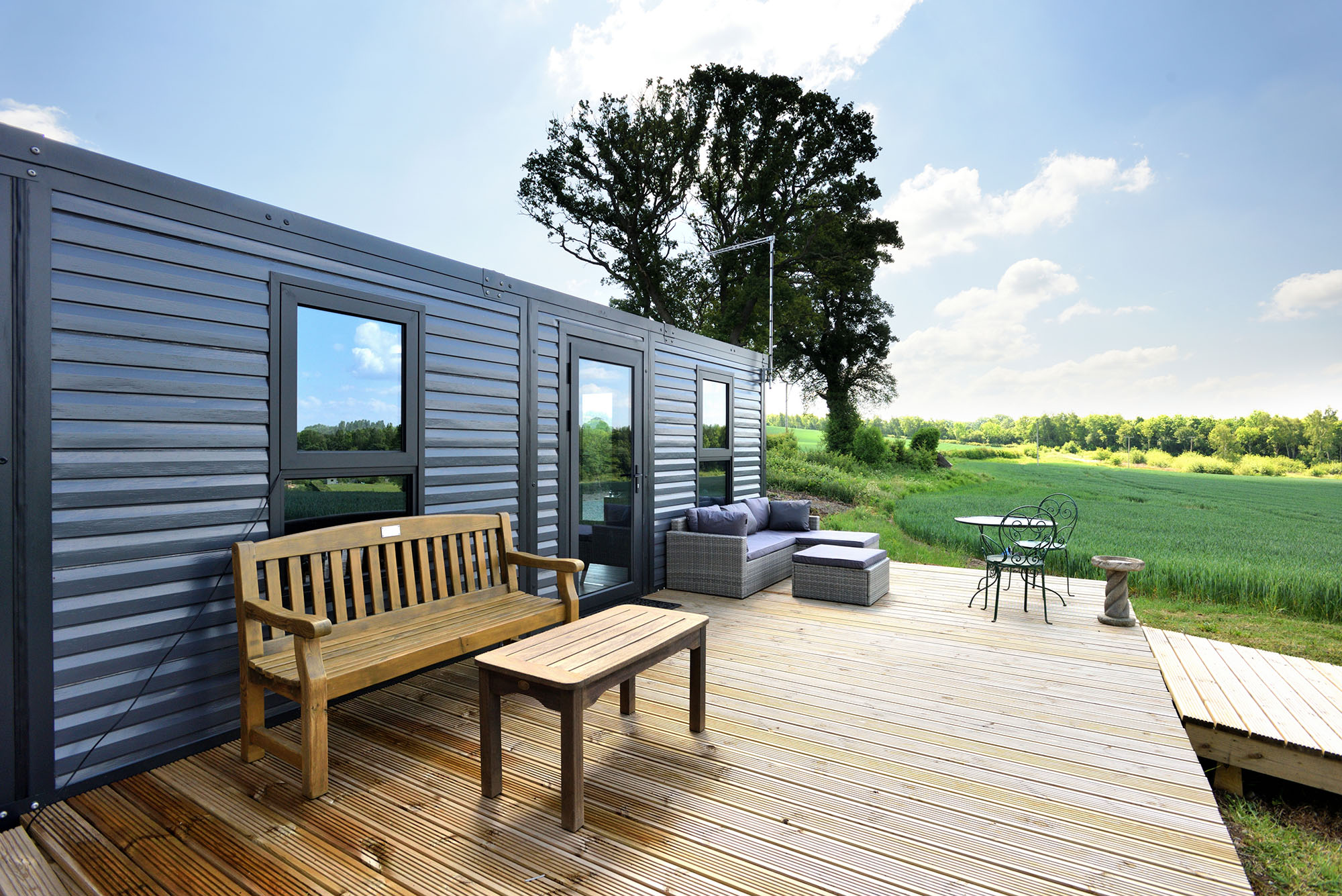 Modern PrefabX Flip building with timber deck in a countryside setting